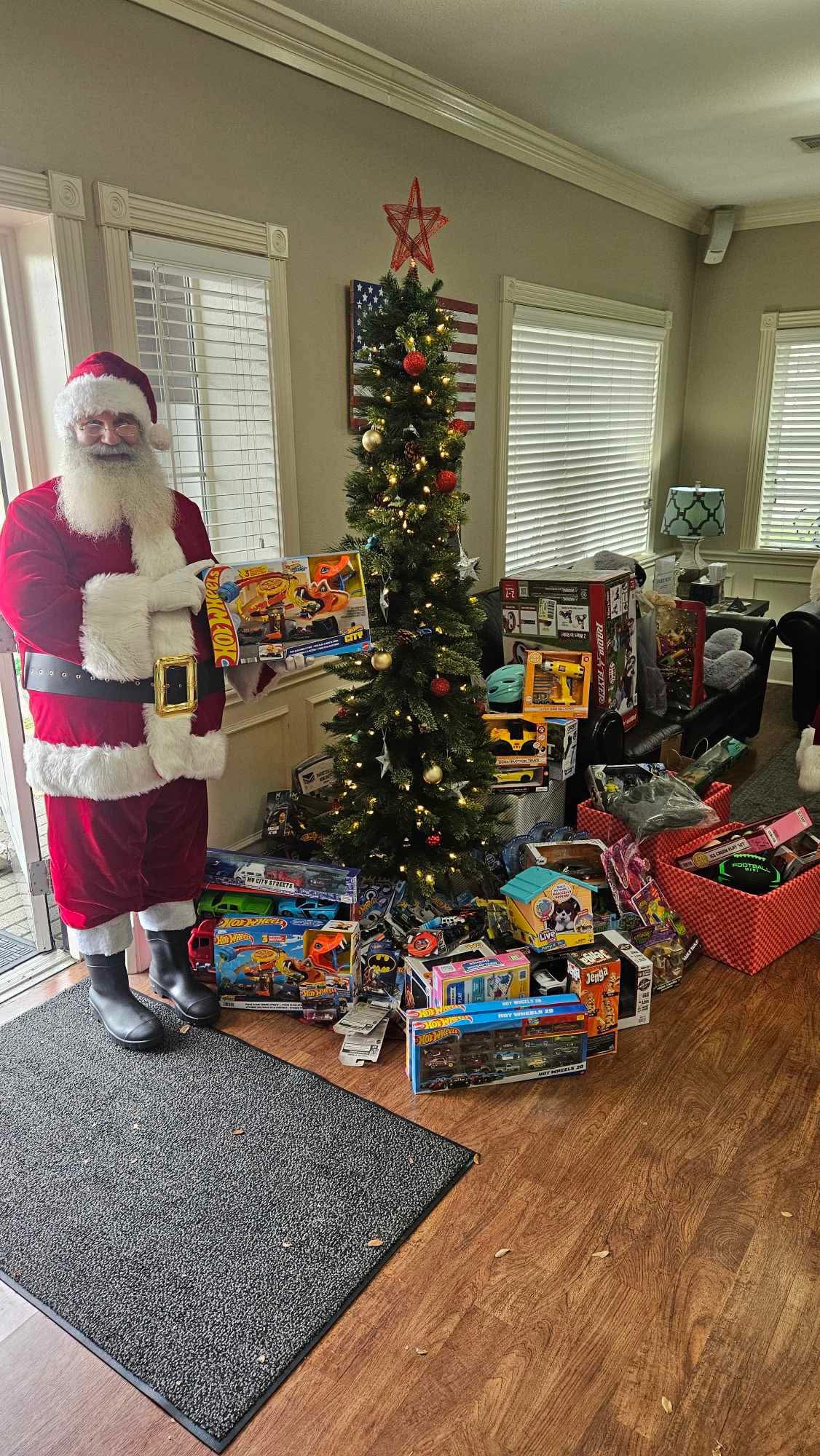 Santa with the toy donation to the Christmas Cottage