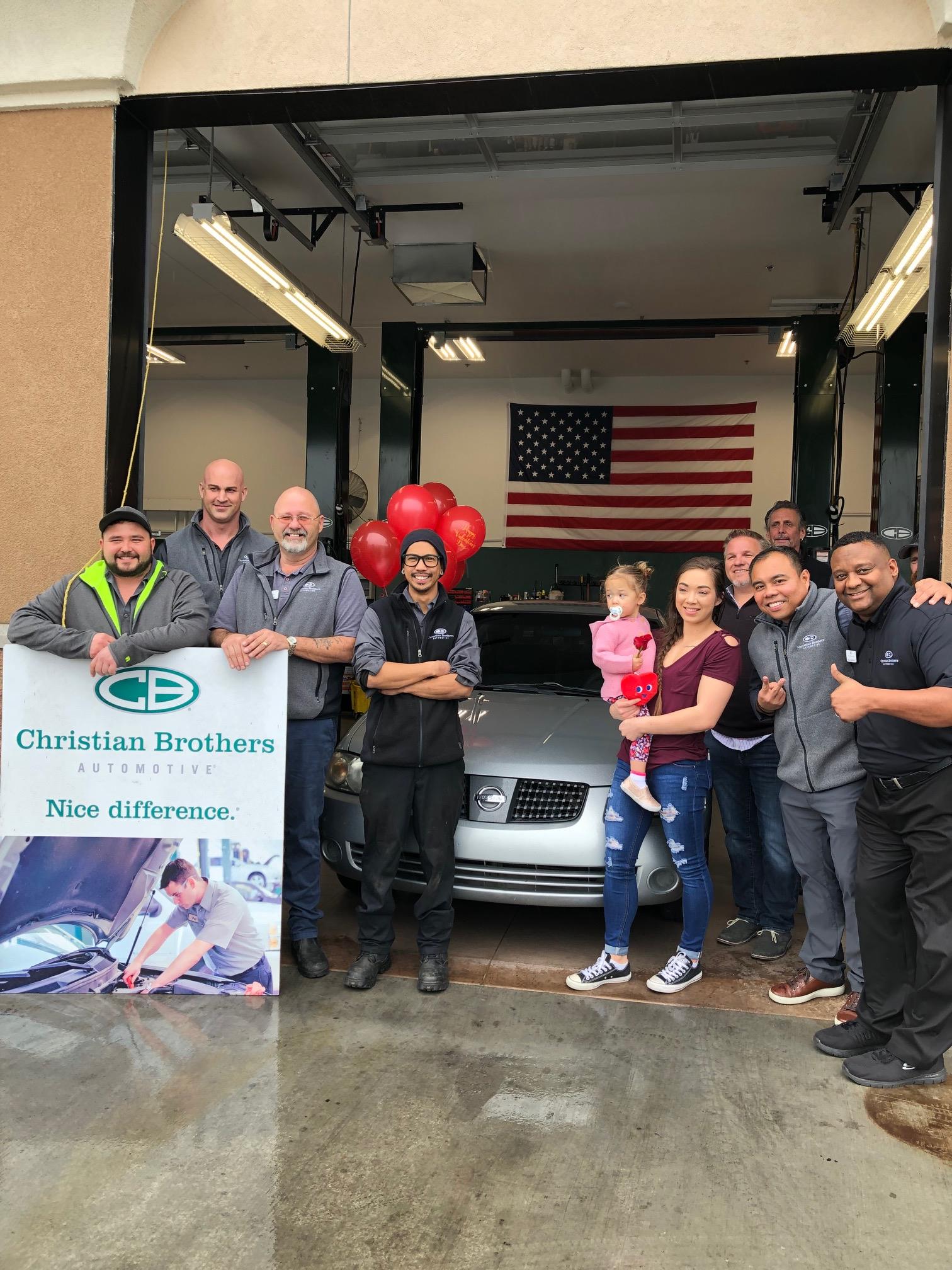 people in front of car in christian brothers automotive shop