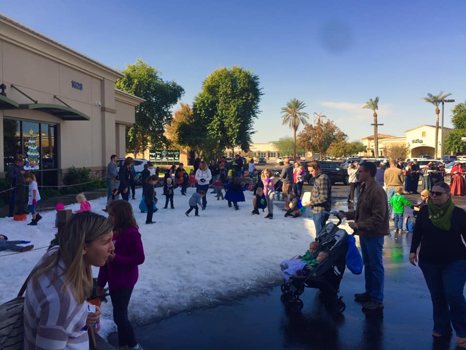 people in parking lot with snow on ground